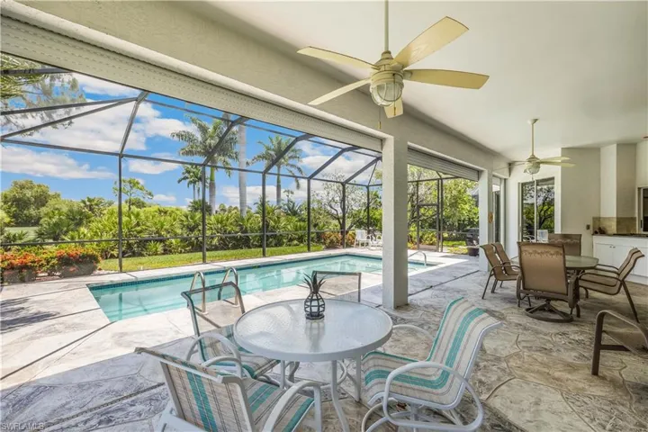 View of swimming pool with a patio area, ceiling fans, and screan enclosure