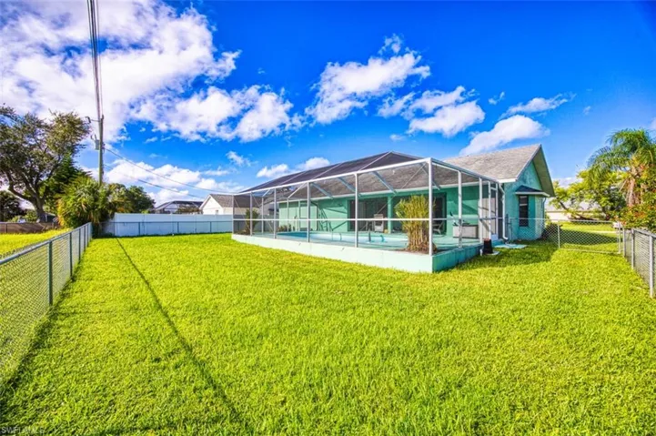 Back of property with a fenced backyard, glass enclosure, a sunroom, and a patio