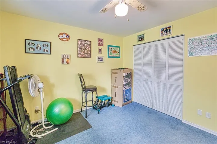 Exercise room with carpet floors and a ceiling fan