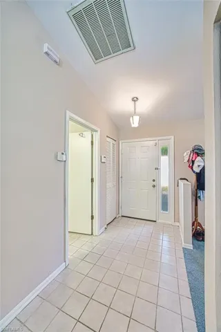 Foyer entrance featuring light tile patterned flooring and baseboards