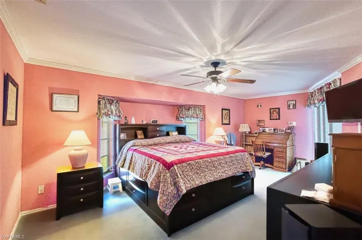 Bedroom with crown molding, ceiling fan, and carpet