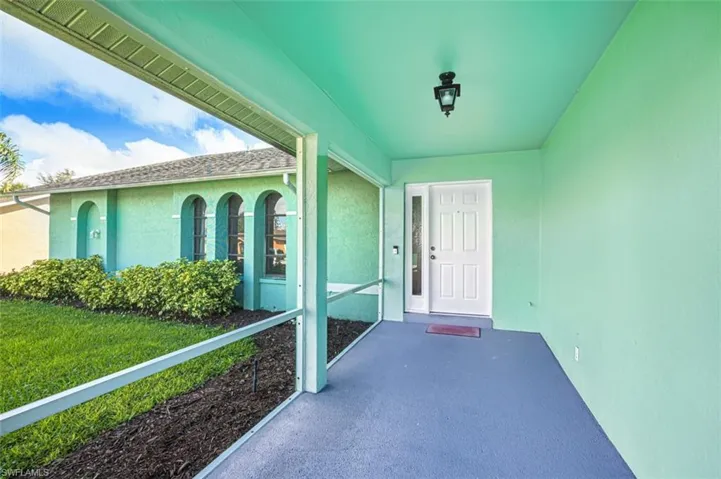 Doorway to property featuring stucco siding and a yard
