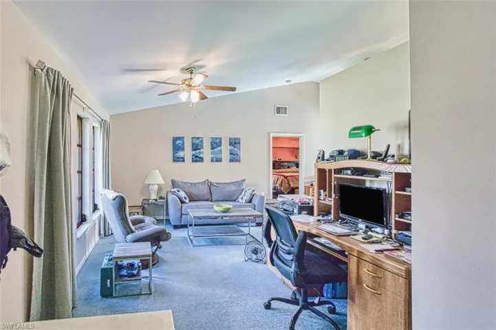 Office with lofted ceiling, a ceiling fan, and carpet