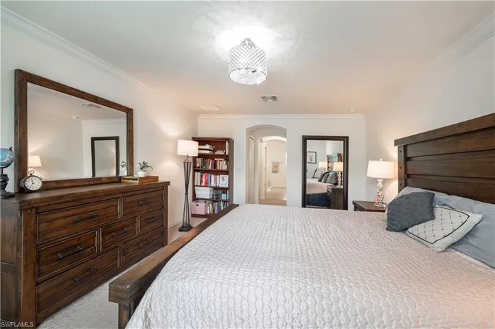 Master Bedroom featuring arched walkways and crown molding