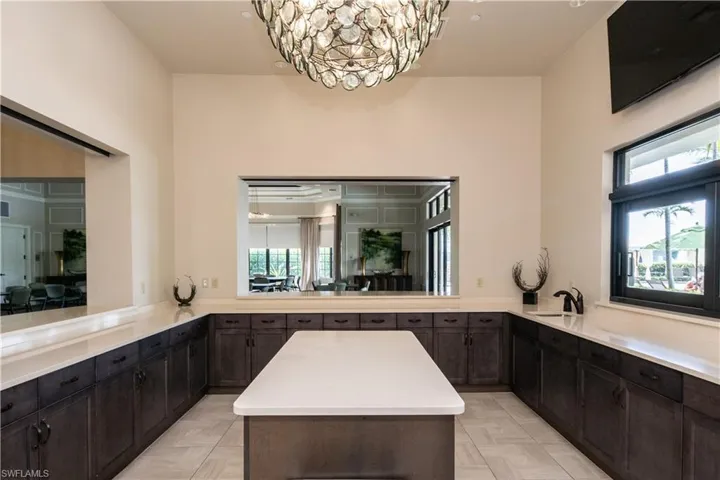 Kitchen featuring a kitchen island, light countertops, a chandelier, and hanging light fixtures