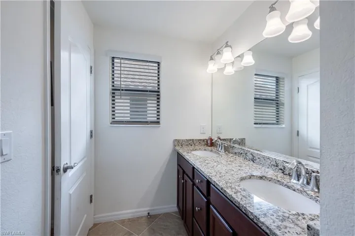 #3 Full bath featuring double vanity, a chandelier, and tile patterned flooring
