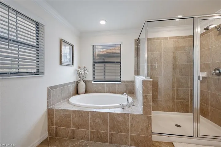 Master Bathroom with a garden tub, a shower stall, crown molding, and tile patterned flooring