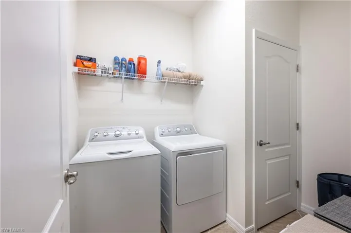 Laundry area featuring washer and dryer and light tile patterned flooring