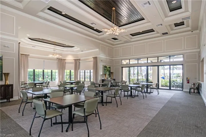 Dining room with a chandelier, a towering ceiling, crown molding, carpet, and coffered ceiling