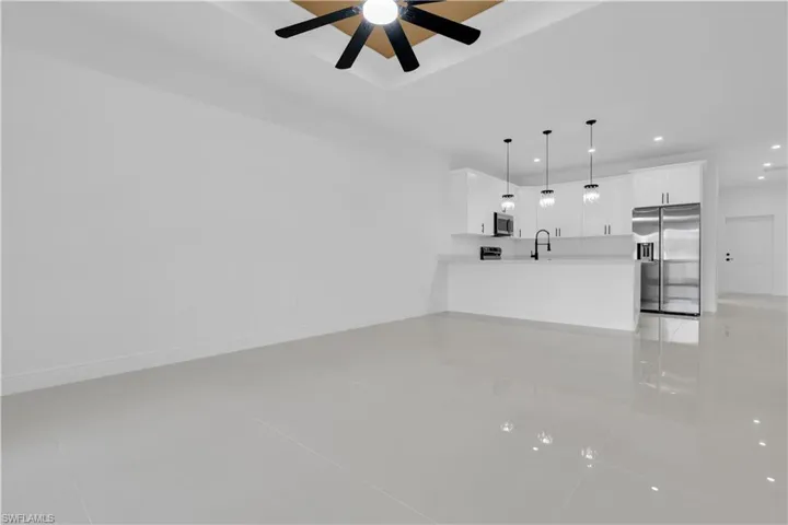 Unfurnished living room with light tile patterned floors, ceiling fan, and recessed lighting