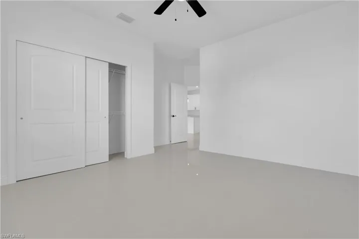 Unfurnished bedroom featuring a closet, ceiling fan, and light tile patterned floors