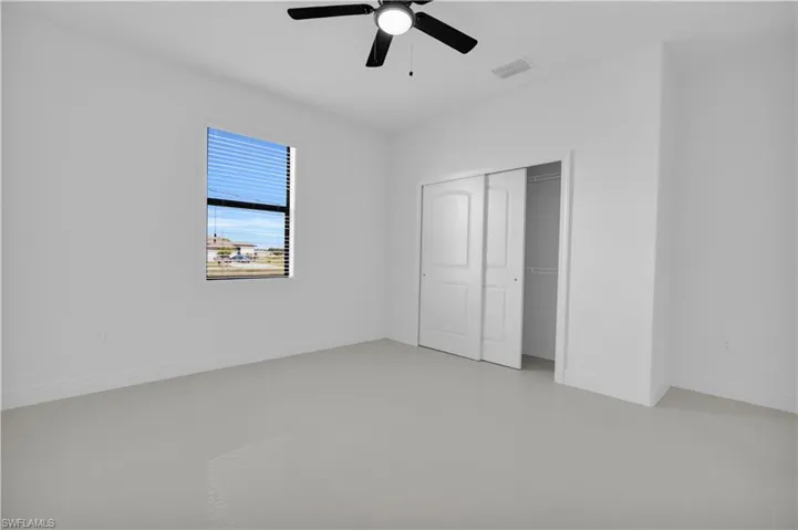 Unfurnished bedroom featuring ceiling fan and a closet