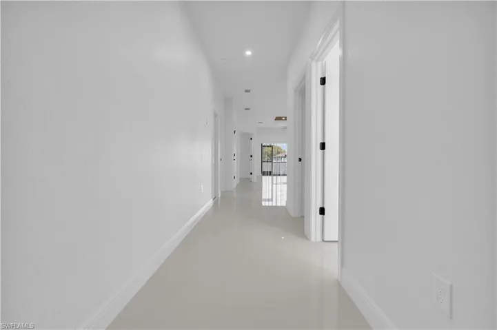 Corridor with baseboards and recessed lighting