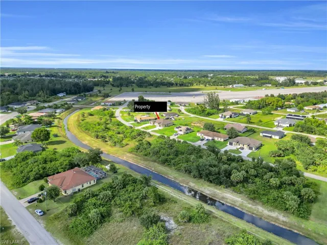 Aerial view of residential area featuring a tree filled landscape and a large body of water