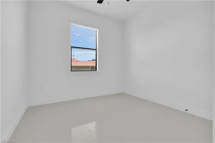 Spare room featuring ceiling fan and baseboards