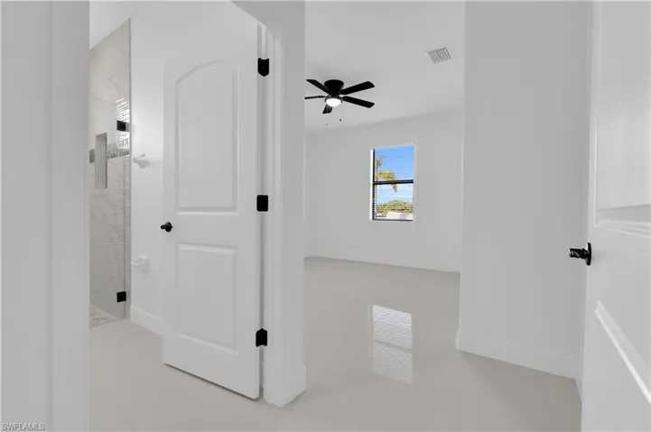 Unfurnished bedroom with ceiling fan and ensuite bath