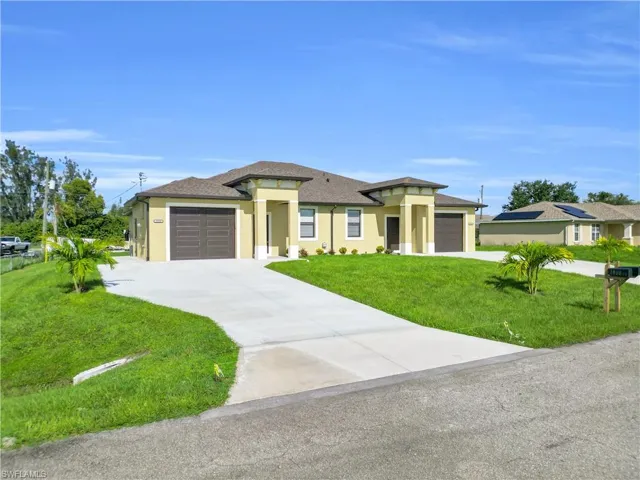 Prairie-style home with a front yard, stucco siding, driveway, an attached garage, and roof with shingles