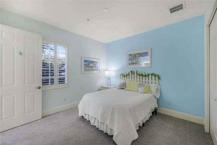 Bedroom with light carpet and a closet