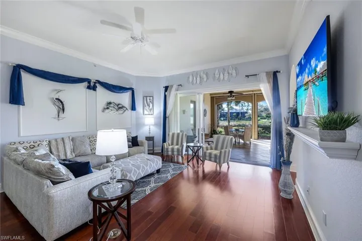 Living room with dark hardwood / wood-style floors and crown molding