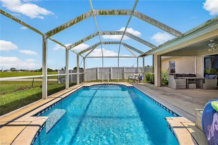 Swimming pool with a patio, a fenced backyard, a ceiling fan, and glass enclosure