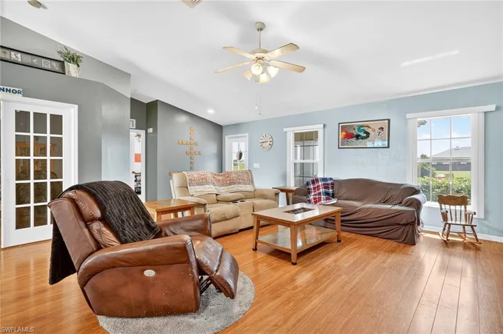 Living area with a ceiling fan and light wood-style floors