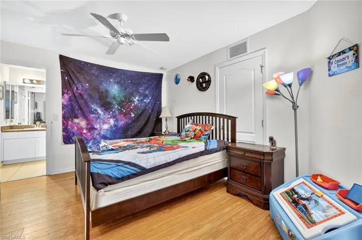 Bedroom featuring light wood-type flooring, ensuite bathroom, and a ceiling fan