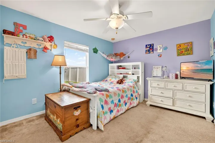 Bedroom with light colored carpet and a ceiling fan