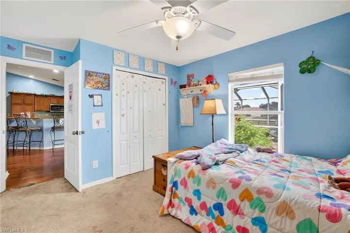 Carpeted bedroom with a closet and a ceiling fan