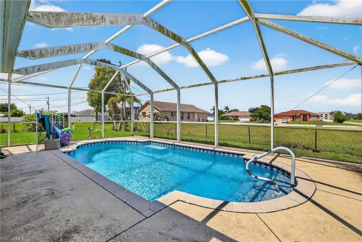 View of swimming pool featuring a patio, a residential view, and glass enclosure