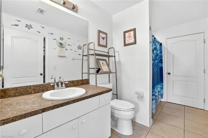 Bathroom with tile patterned floors, vanity, and curtained shower