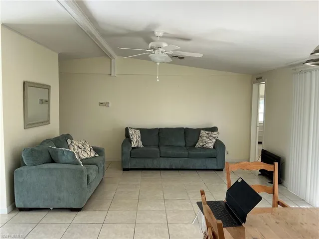 Living room with light tile patterned flooring and ceiling fan