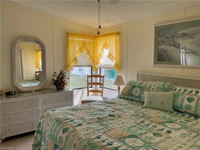 Bedroom with ornamental molding, a textured ceiling, and tile patterned flooring
