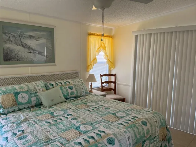 Bedroom featuring a textured ceiling, crown molding, and tile patterned flooring