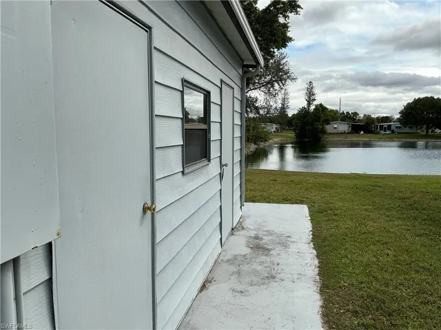 View of home's exterior with a water view and a lawn