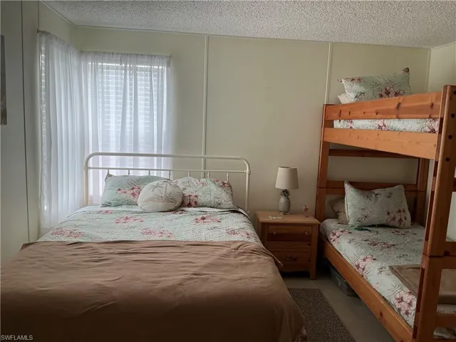 Bedroom with a textured ceiling and light tile patterned floors
