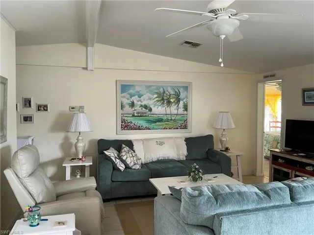 Tiled living area featuring ceiling fan