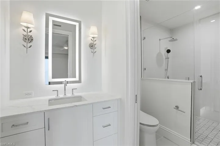 Bathroom featuring a shower stall, vanity, and light tile patterned floors