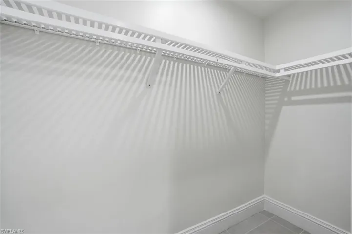 Walk in closet with light tile patterned floors