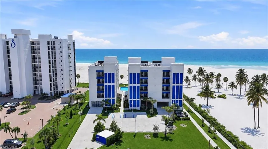 Expansive land parcel with direct beach access, surrounded by established buildings and roadways - Virtually Edited Image