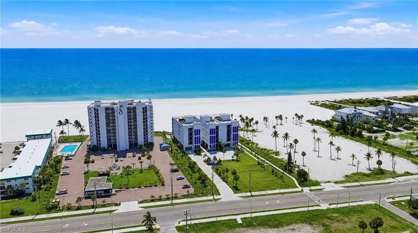 Expansive land parcel with direct beach access, surrounded by established buildings and roadways - Virtually Edited Image