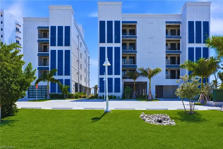 Contemporary multi-story building featuring white siding and blue accents - Virtually Edited Image
