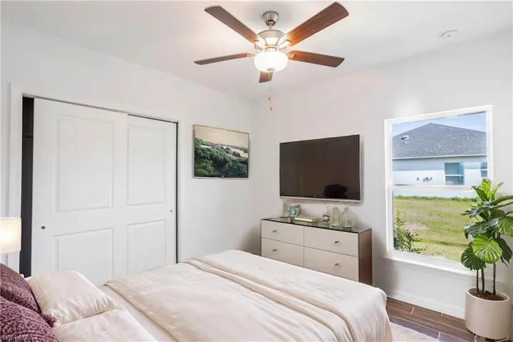 Bedroom featuring wood-type flooring, a closet, and ceiling fan