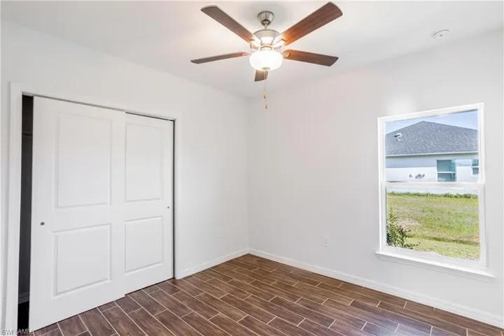Unfurnished bedroom with ceiling fan and a closet