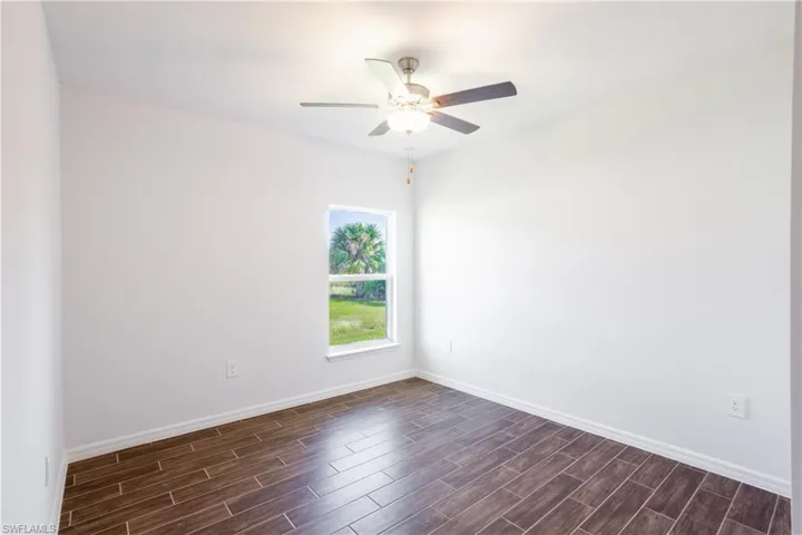 Spare room with dark hardwood / wood-style floors and ceiling fan