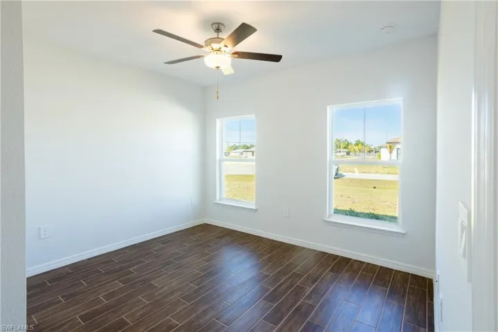 Spare room featuring ceiling fan and dark hardwood / wood-style flooring