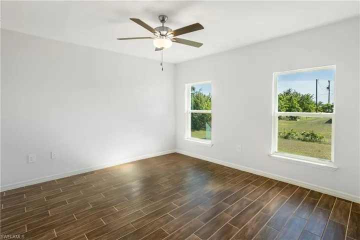 Spare room with ceiling fan and dark hardwood / wood-style flooring
