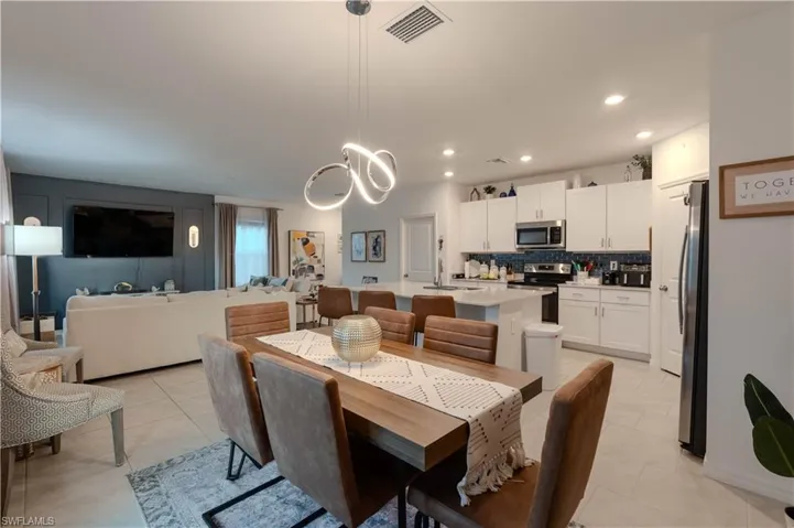 Dining space with recessed lighting, light tile patterned floors, and a chandelier