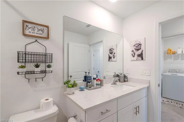Bathroom with washer / dryer, vanity, and light tile patterned floors