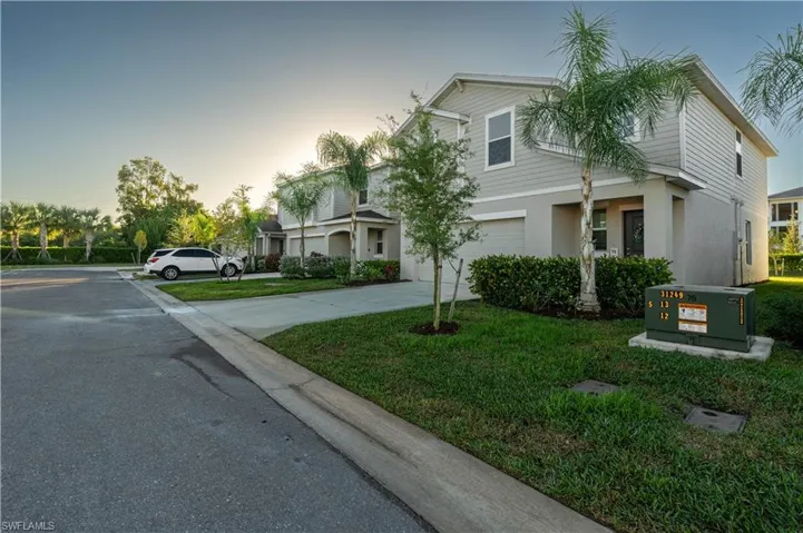 View of front of home featuring concrete driveway, stucco siding, and a front lawn