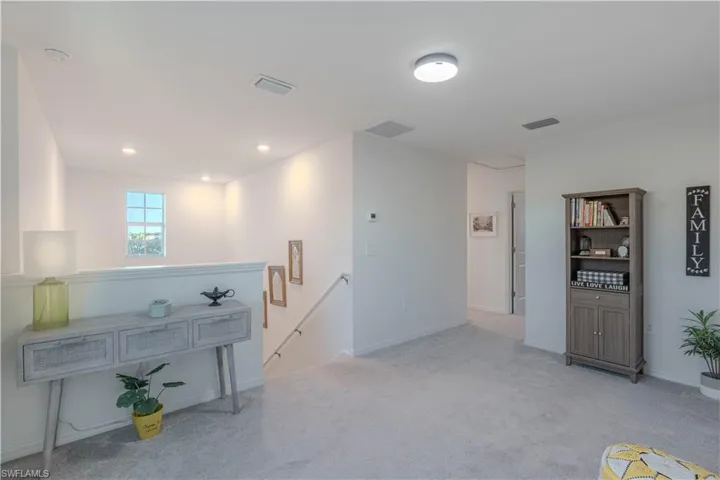 Unfurnished room featuring an upstairs landing, carpet, and recessed lighting